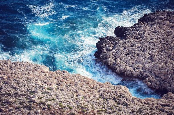 美丽的无人居住的风景多岩石的海岸,蓝色波