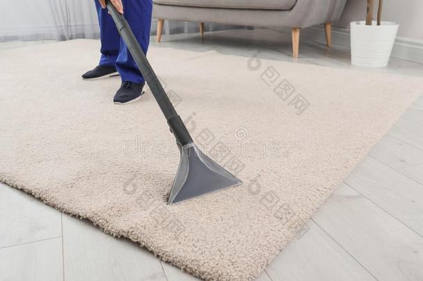 男人消除泥土从地毯和真空清洁剂在室内,关