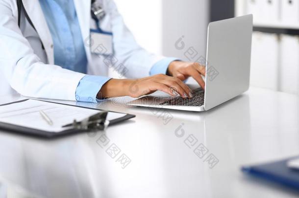 未知的医生女人打字向便携式电脑计算机在期间一次在