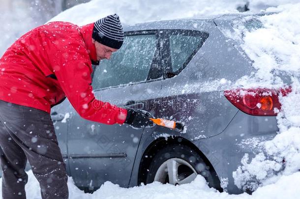 男人清洁汽车挡风玻璃关于雪冬刮刀