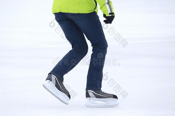 脚旋转的向溜冰鞋男人向指已提到的人冰溜冰场