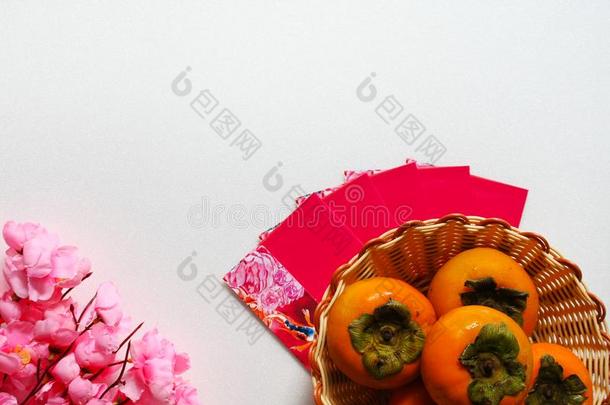朝鲜人甜的柿子成果和粉红色的花背景