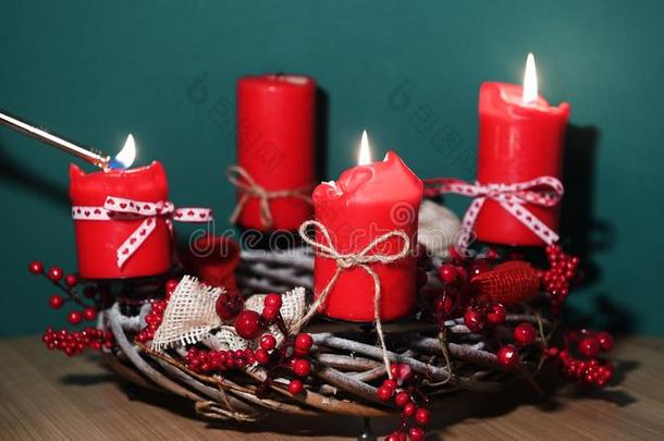 现代的圣诞节花环和num.四红色的蜡烛向木制的表面