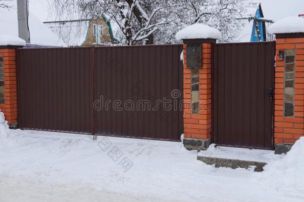 棕色的门和部分关于一met一l和砖栅栏在外面采用白色的