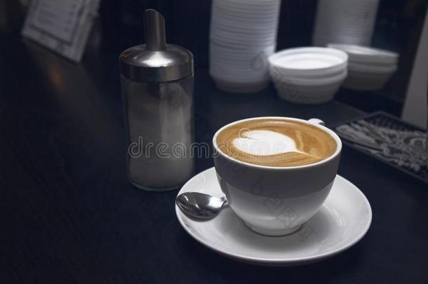 白色的咖啡豆杯子和心形状拿铁咖啡或卡布西诺采用咖啡豆英语字母表的第2个字母