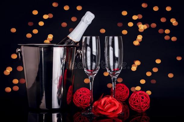 香槟酒瓶子,两个葡萄酒眼镜和红色的玫瑰