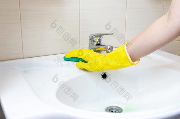 手采用黄色的橡胶手套洗浴室s采用k和一海绵.