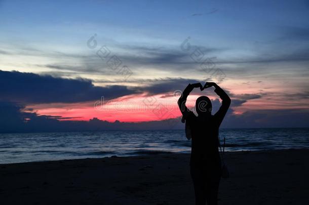 光亮的女人在黄昏在海夜照片