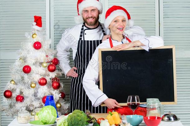 男人和女人厨师SociedeAnonimaNacionaldeTransportsAereos国家航空运输公司帽子在近处圣诞节树