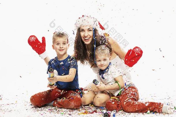 美丽的年幼的女人和孩子们采用圣诞节帽子采用五<strong>彩纸</strong>屑