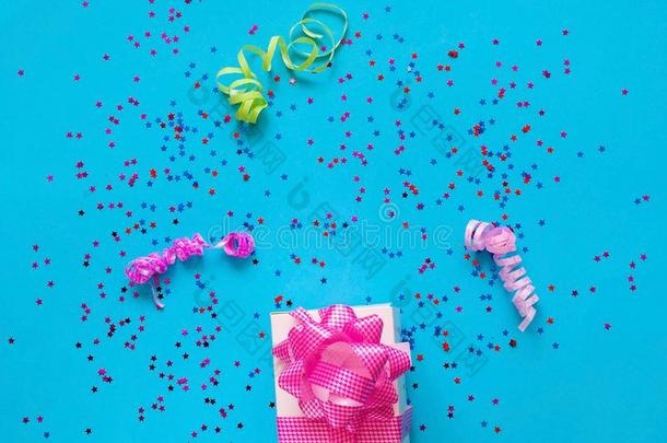 赠品盒和粉红色的弓向蓝色背景和发火花.节日的
