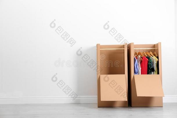衣柜盒和衣服反对光墙在室内.