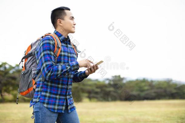 男人享有徒步旅行旅游和吃草他的电话