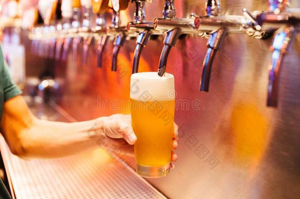 男人传布手艺啤酒从啤酒<strong>熄灯</strong>号音采用冷冻的玻璃和泡沫