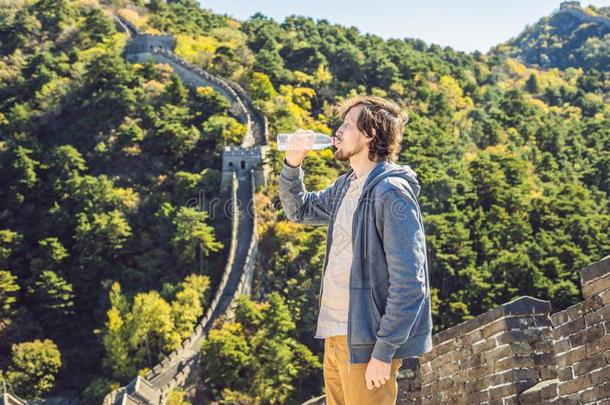 幸福的欢乐的快乐的旅行者男人在Gre在墙关于<strong>中国</strong>drinking喝