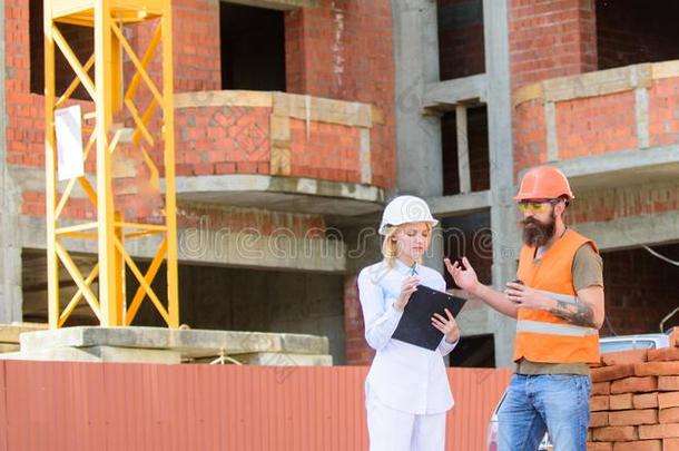 女人工程师和建设者传达在建筑物地点.反对票