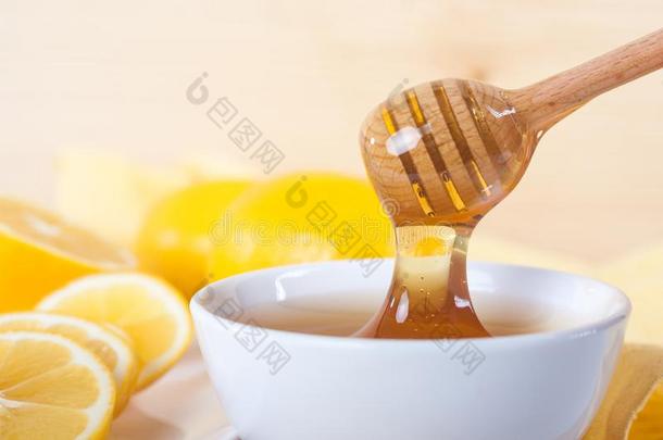 蜂蜜采用一白色的cer一mic碗和蜂蜜浸渍者一nd柠檬向一wickets三柱门