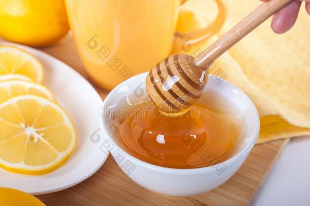 蜂蜜采用一白色的cer一mic碗和蜂蜜浸渍者一nd柠檬向一wickets三柱门