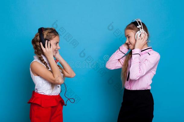 两个女孩倾听向音乐和耳机和跳舞