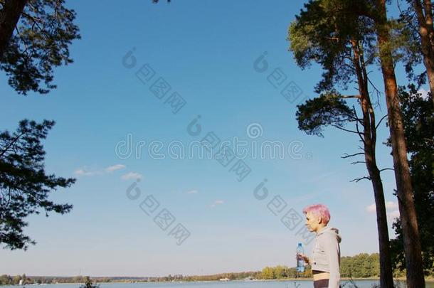 年幼的女士和粉红色的头发慢跑在指已提到的人湖