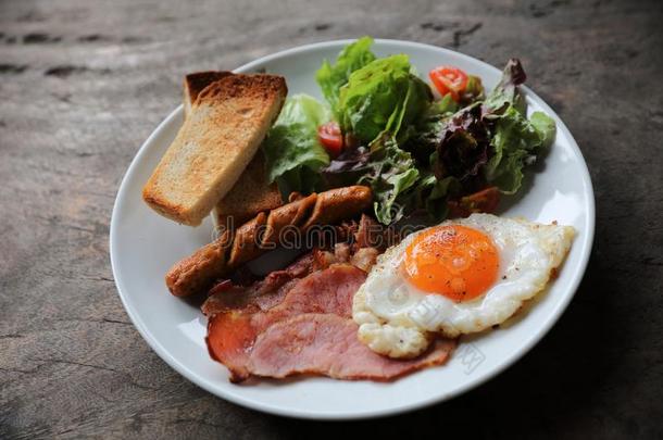 英语早餐喝醉了的鸡蛋,火腿,香肠,培根,沙拉和干杯