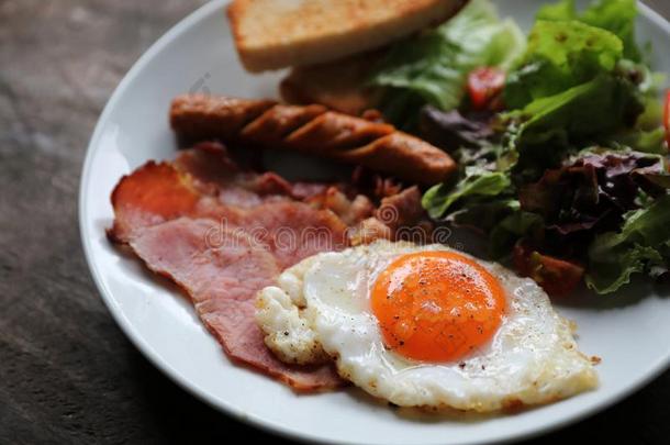 英语早餐喝醉了的鸡蛋,火腿,香肠,培根,沙拉和干杯