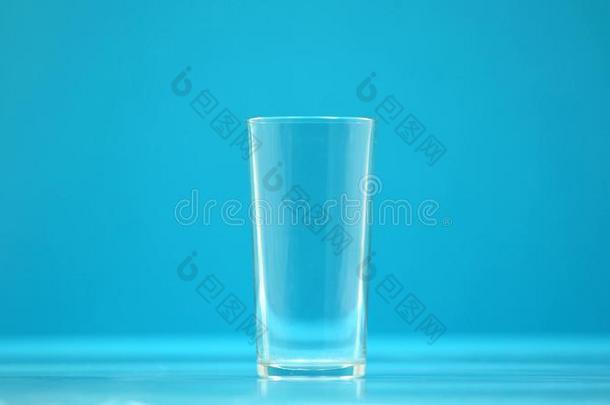 空的喝饮料杯子,玻璃为奶和水向蓝色背景,