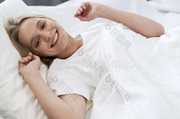 健康的睡向整形手术的床垫,幸福的十几岁的女孩醒着的