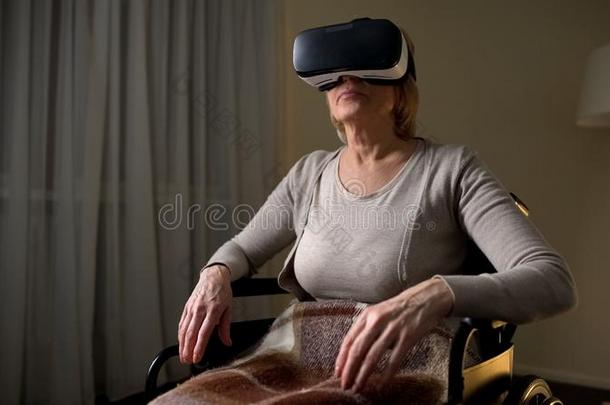 成熟的女士采用轮椅wear采用gVirtualReality虚拟现实戴在头上的耳机或听筒向看见魔力的技术