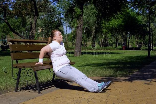 极为肥胖<strong>的</strong>女孩锻炼向长凳采用公园,勤勉,运动可用