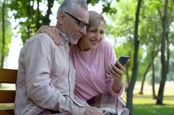 幸福的较高的对观察智能手机照片,退休利苏