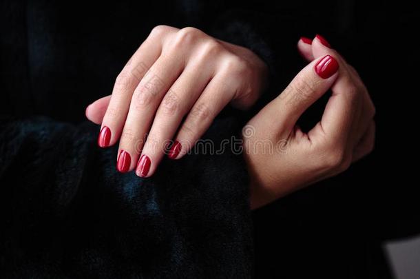华丽的修指甲,克莱西奇红色的颜色钉子擦光,特写镜头照片.