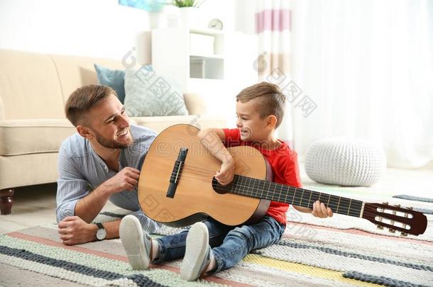 父亲教学他的小的儿子向比赛吉他
