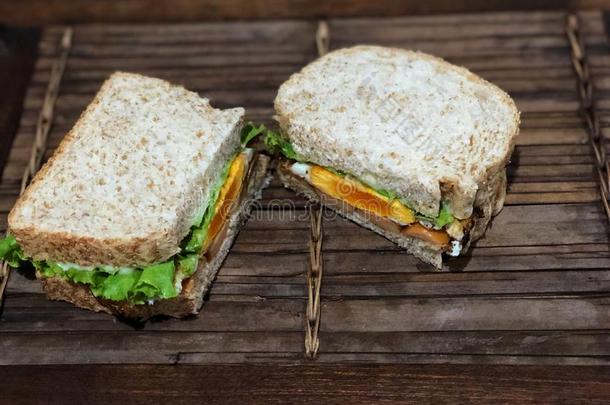 新鲜的三明治向指已提到的人木制的表,美味的早餐.