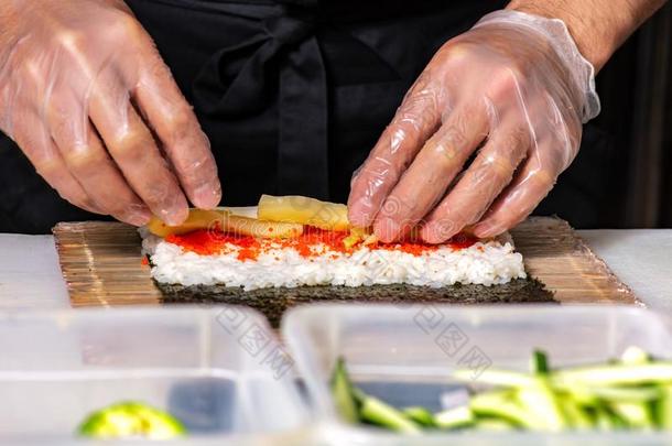 特写镜头关于厨师手旋转的在上面寿司向指已提到的人厨房