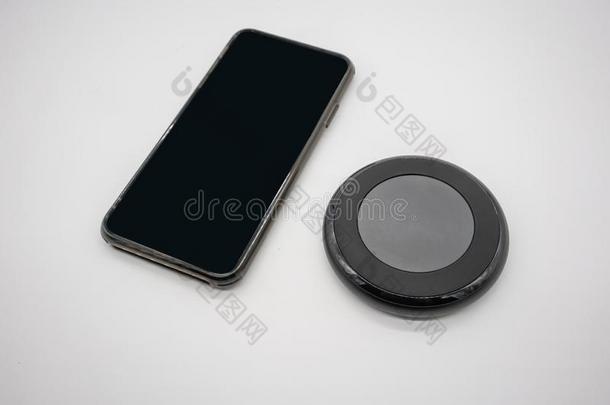 黑的可移动的电话放置在旁边黑的圆形的形状不用电线的委托者
