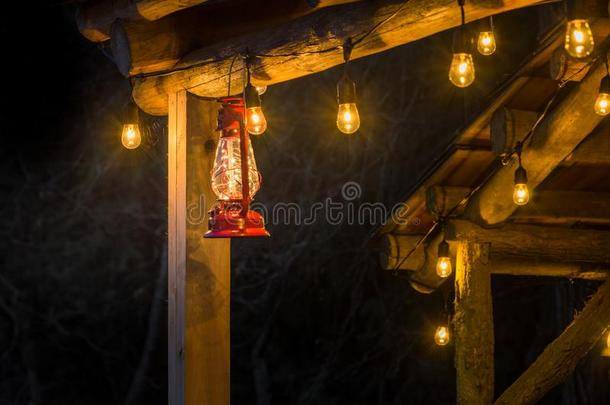 红色的金属暴风雨灯笼悬在外面乡村的记录小木屋.