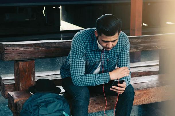 亚洲人男人使用可移动的电话选择歌曲为倾听音乐