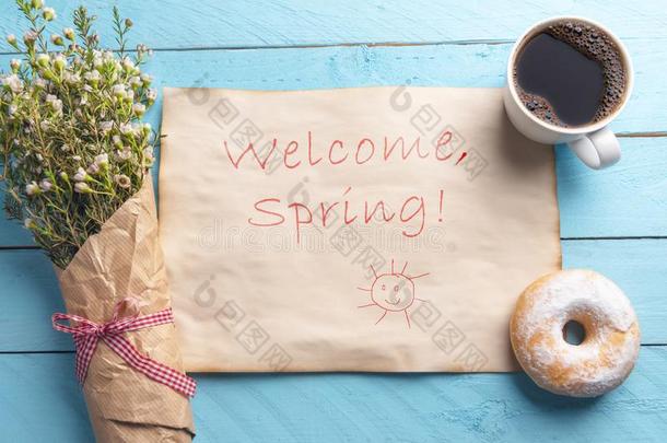 欢<strong>迎春</strong>季文本和花和咖啡豆向蓝色书桌
