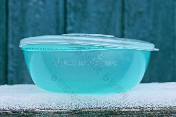关闭着的蓝色塑料制品碗看台向白色的雪在外面