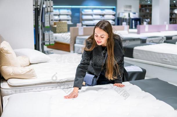 顾客女人购买新的家具-床采用一商店