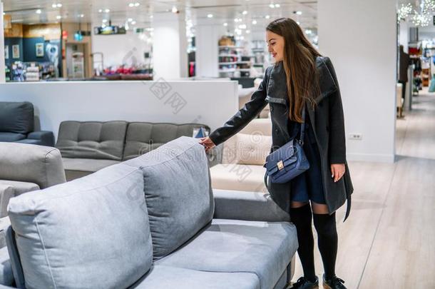 顾客女人购买新的家具-沙发或长沙发椅采用一st或e