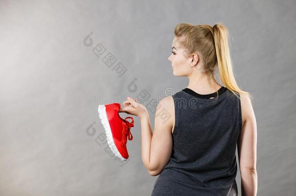 女人举向运动装教练鞋子
