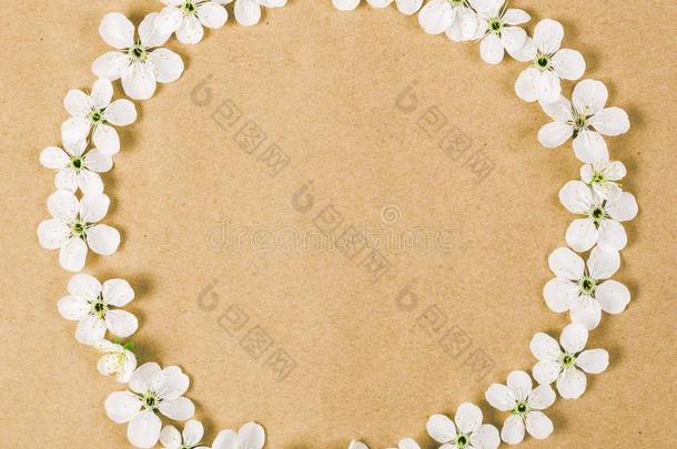 圆形的框架花环使关于白色的春季花向棕色的纸英语字母表的第2个字母