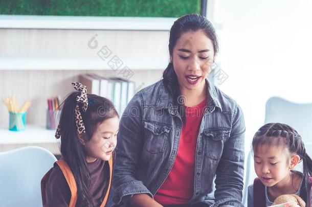 教师阅读故事书向幼儿园学生