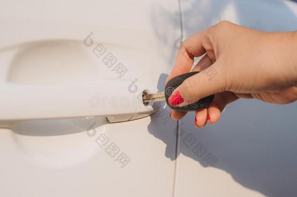 女人和汽车钥匙.开幕汽车门.女人`英文字母表的第19个字母手开锁一门