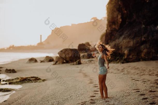 年幼的苗条的美丽的女人女孩向日落海滩,独立经营的电影院等方式.Romania罗马尼亚