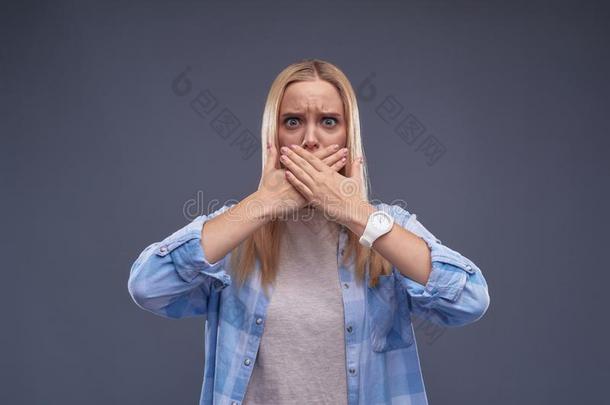 恼怒的年幼的女士采用蓝色衬衫cover采用g口和手
