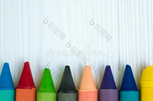 颜色鲜艳的蜡用<strong>彩色蜡笔</strong>画铅笔向白色的木材表和复制品土壤-植物-大气连续体