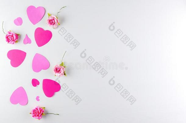 手-使粉红色的爱心和赠品盒隔离的向白色的木制的